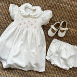 Abito battesimale newborn in twill latte ricamo punto smock rosa F25I130VEZL